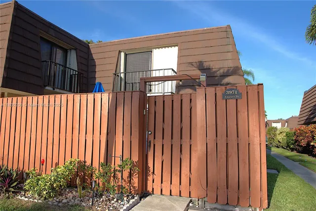 a view of a house with a wooden fence