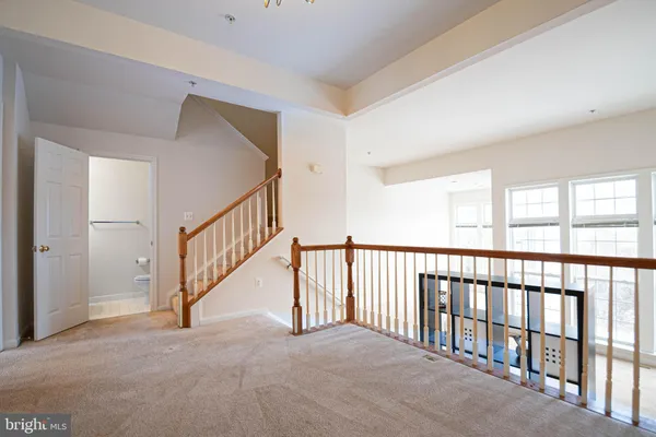 a kitchen with stainless steel appliances granite countertop a sink dishwasher a stove a refrigerator white cabinets and wooden floor