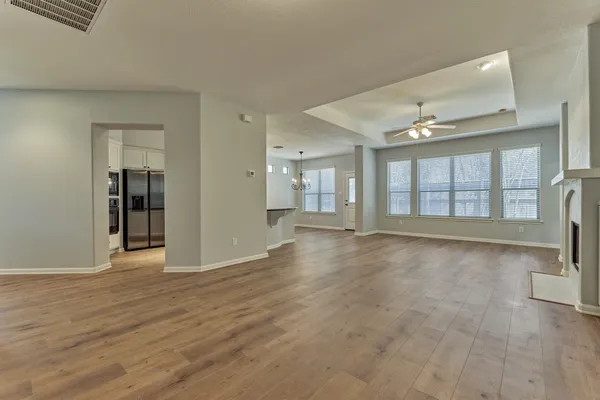 a view of an empty room with a fireplace and a window