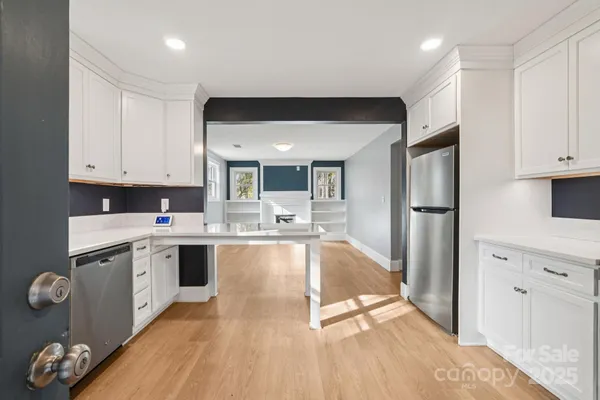 a large kitchen with stainless steel appliances granite countertop a refrigerator and a sink