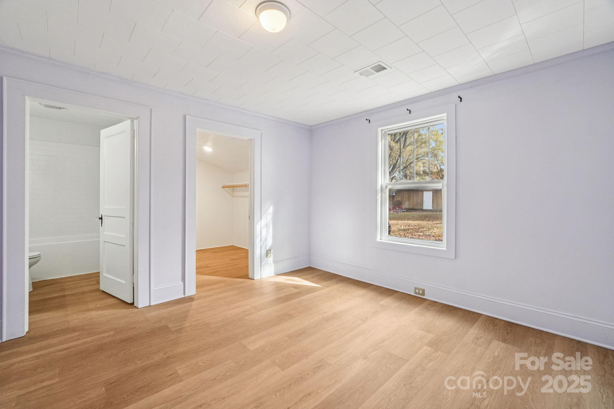 611 Sumner Street Kannapolis, NC 28083 - Photo 14 of 39 a view of an empty room with wooden floor and a window