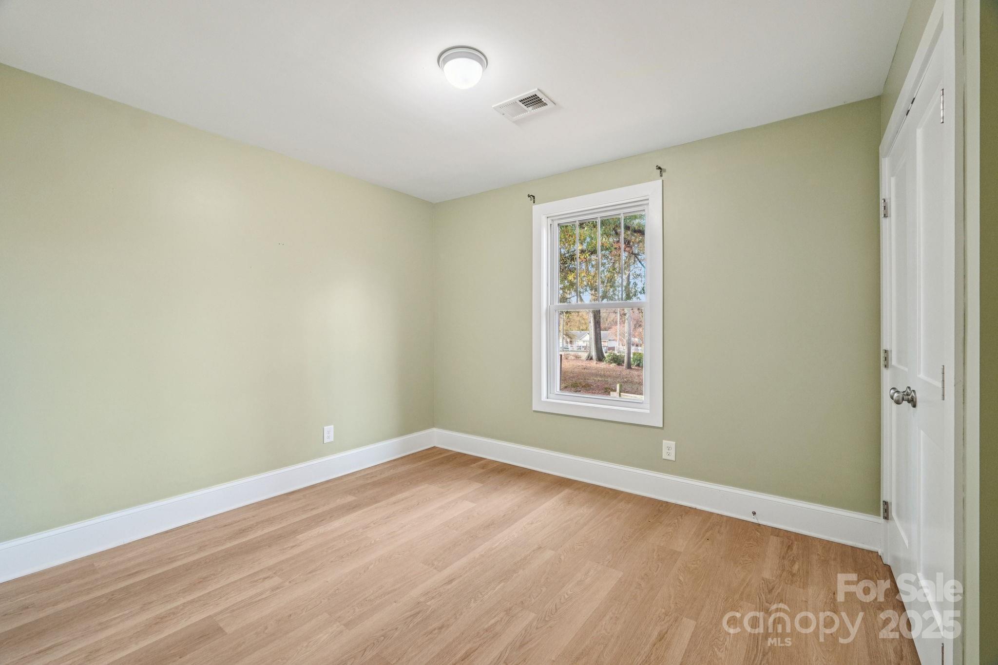 611 Sumner Street Kannapolis, NC 28083 - Photo 22 of 39 an empty room with wooden floor and windows