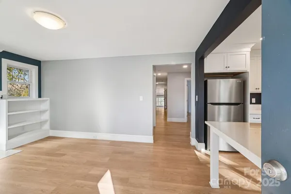 a view of a kitchen with wooden floor and a refrigerator