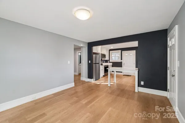 a view of empty room with wooden floor and floor to ceiling window
