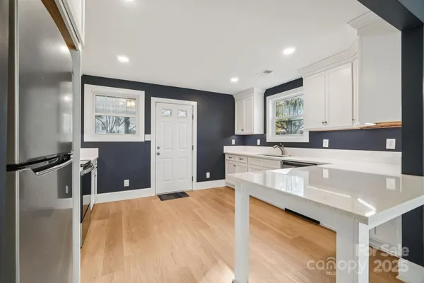 a large kitchen with kitchen island a sink stainless steel appliances and cabinets