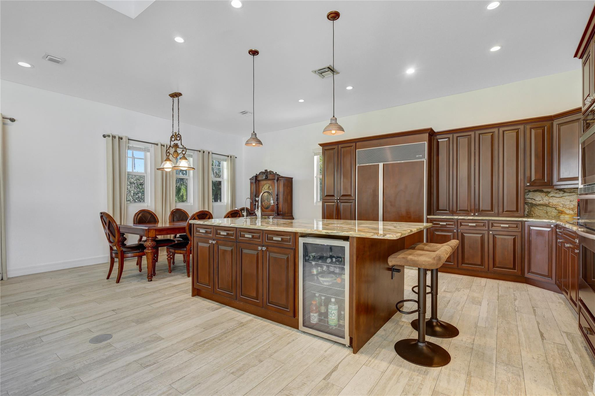 6601 Appaloosa Trail Southwest Ranches, FL 33330 - Photo 15 of 49 a kitchen with granite countertop a stove a sink a dining table and chairs with wooden floor