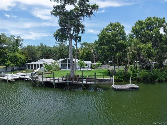 an aerial view of a house with a garden and lake view