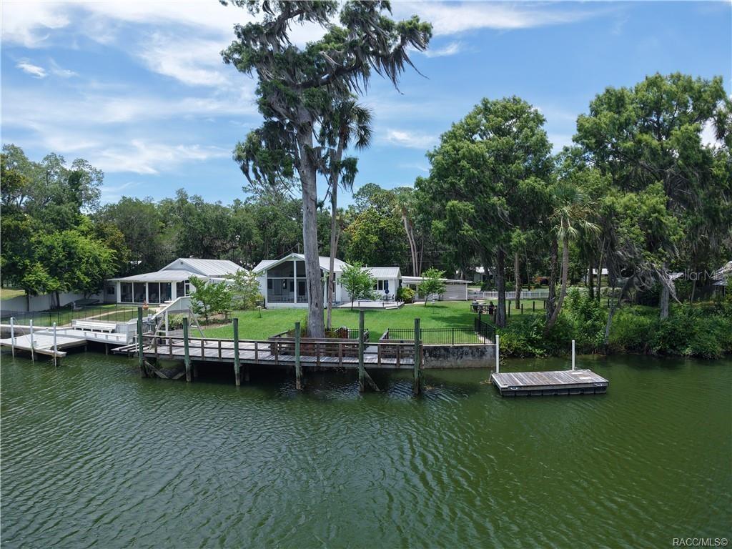 an aerial view of a house with a garden and lake view