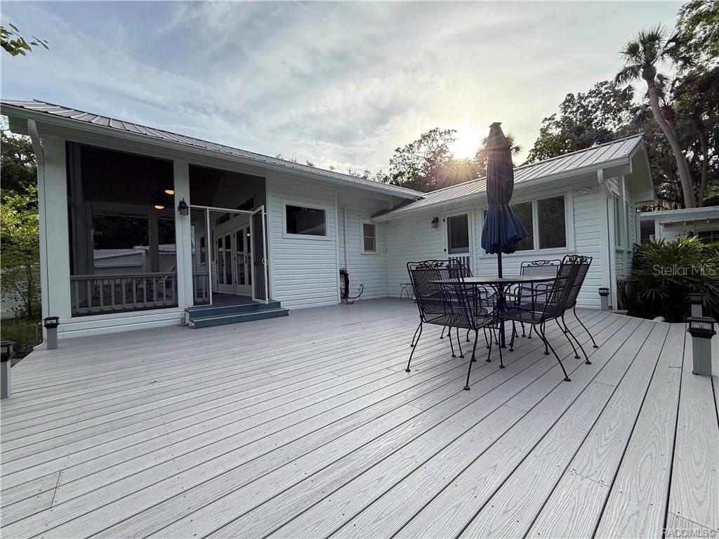 5217 Riverside Drive Yankeetown, FL 34498 - Photo 23 of 54 a roof deck with table and chairs and potted plants