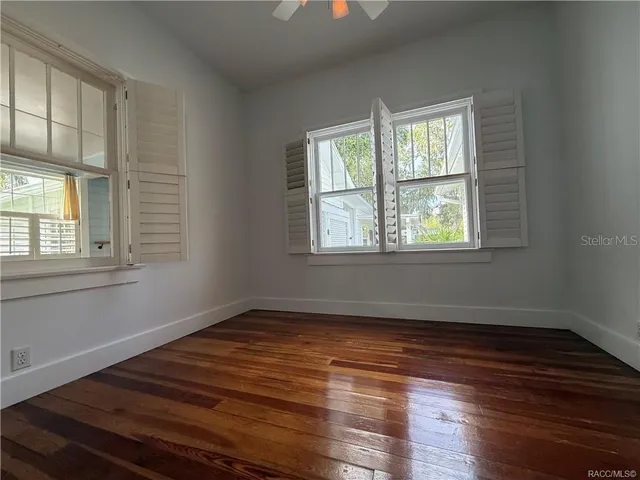 a kitchen with granite countertop cabinets stainless steel appliances wooden floor and a window