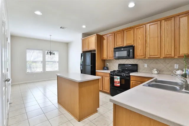 a kitchen with stainless steel appliances granite countertop a stove top oven a sink a counter top space and cabinets