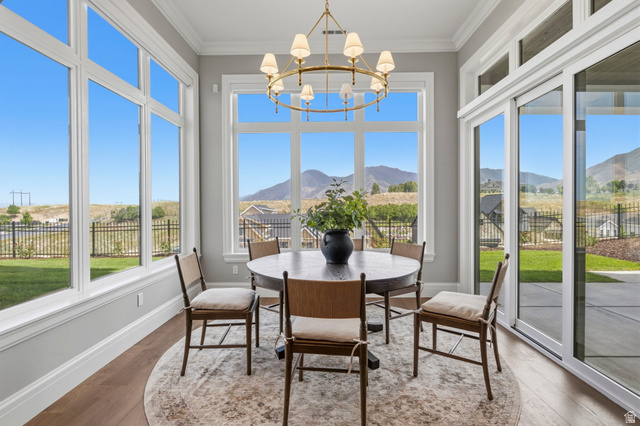 115 East Hidden Ridge Lane, Unit 42 Mapleton, UT 84664 - Photo 61 of 103 Dining area featuring a contemporary chandelier, expansive windows, sliding glass doors, crown molding, and wood-finish flooring