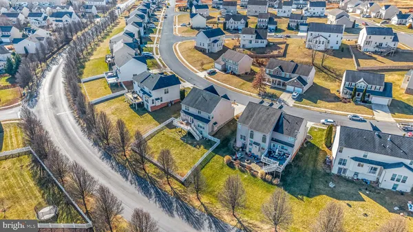 an aerial view of a swimming pool with outdoor seating and yard