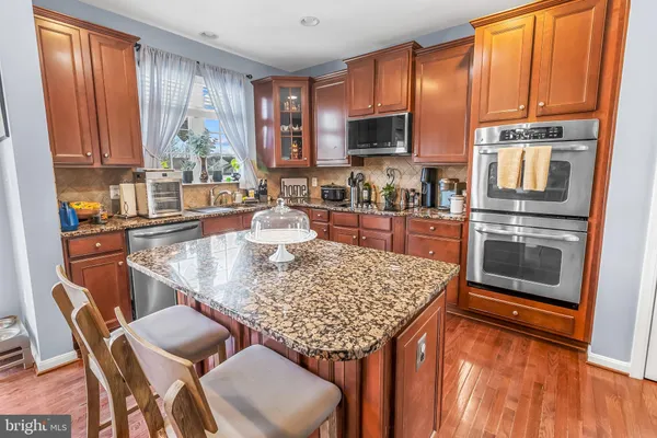 a kitchen with stainless steel appliances granite countertop a stove top oven a sink counter space and dining table