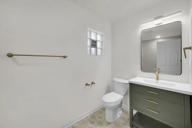 a bathroom with a toilet sink and mirror