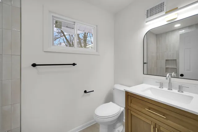 a bathroom with a toilet sink and mirror