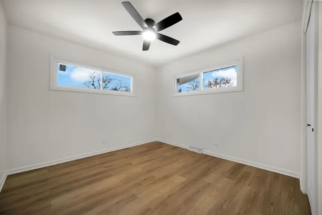 a view of empty room with wooden floor