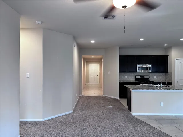 a kitchen with stainless steel appliances granite countertop a sink and a refrigerator