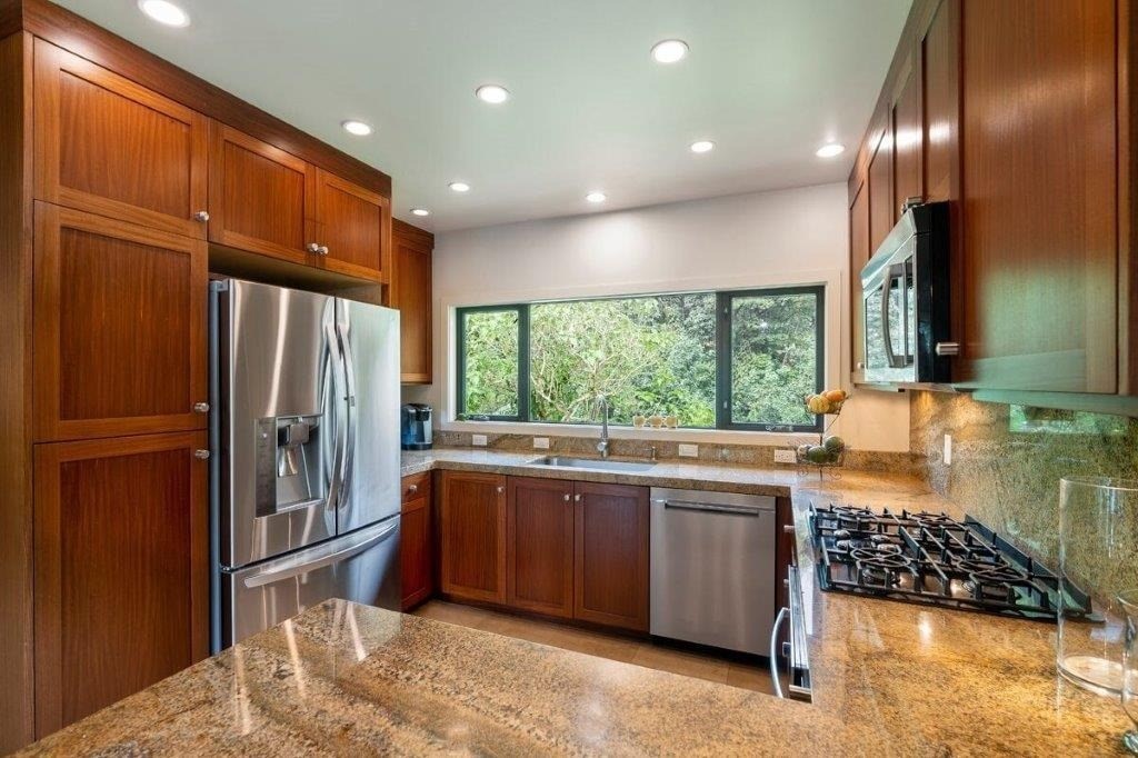 4318 Punee Road Koloa, HI 96756 - Photo 5 of 23 a kitchen with stainless steel appliances granite countertop a refrigerator a sink a stove and a wooden cabinets