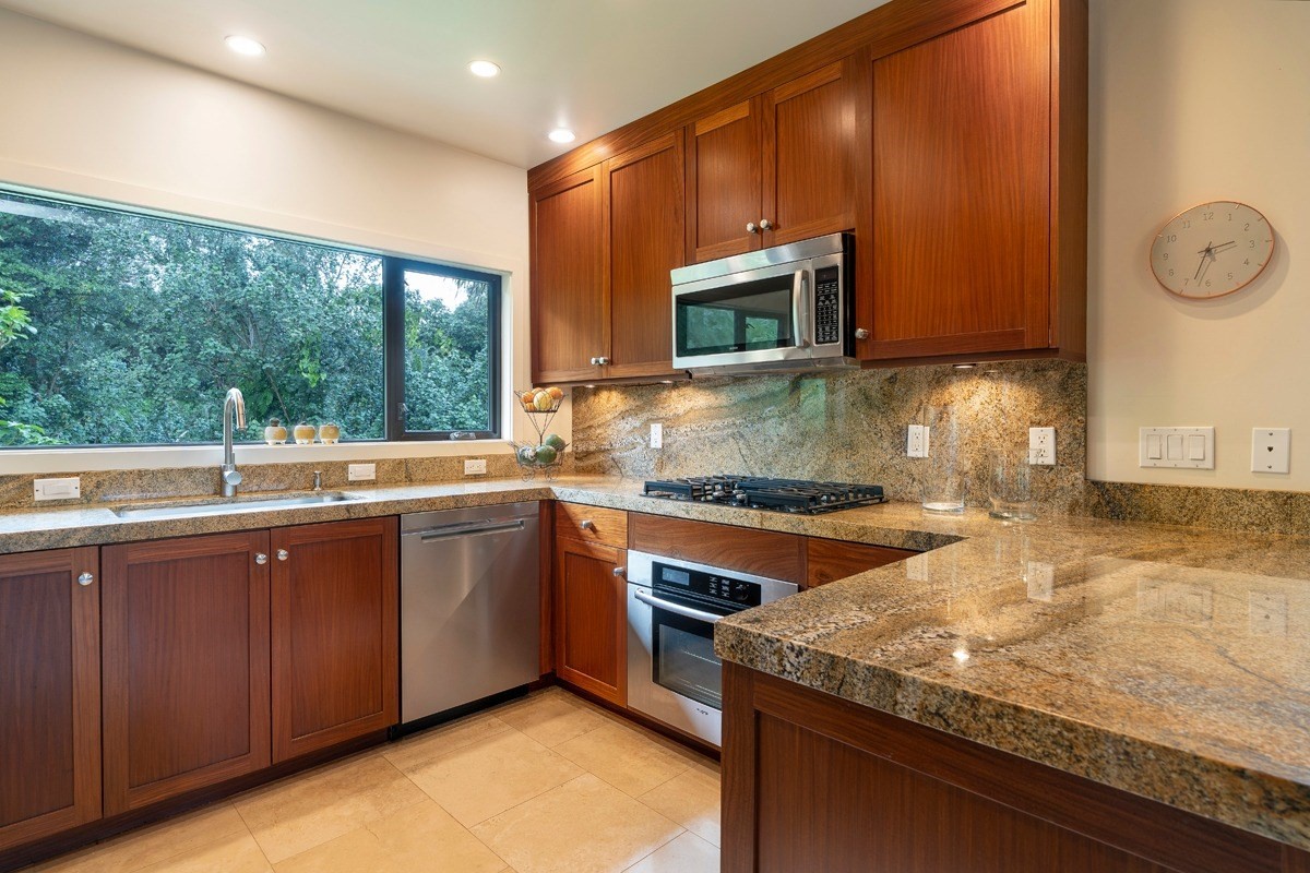 4318 Punee Road Koloa, HI 96756 - Photo 6 of 23 a kitchen with stainless steel appliances granite countertop wooden cabinets and a sink