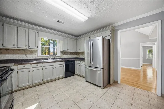 a kitchen with granite countertop a refrigerator and a stove top oven