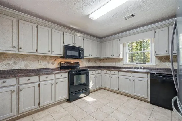 a kitchen with granite countertop white cabinets white stainless steel appliances with a sink and dishwasher