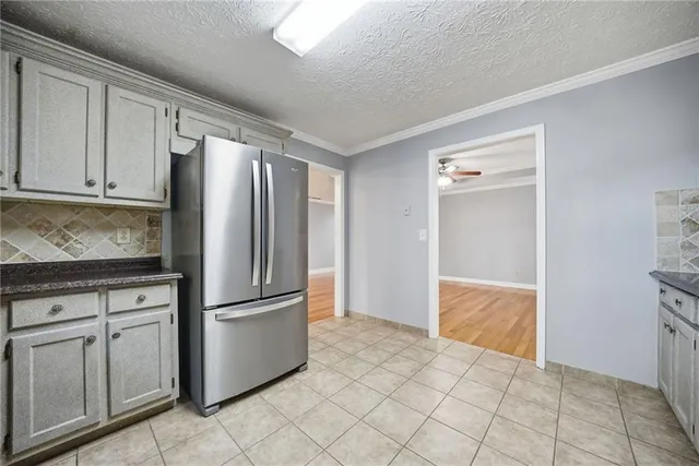 a kitchen with granite countertop a refrigerator and cabinets
