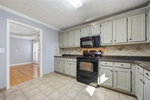 a kitchen with granite countertop white cabinets and stainless steel appliances