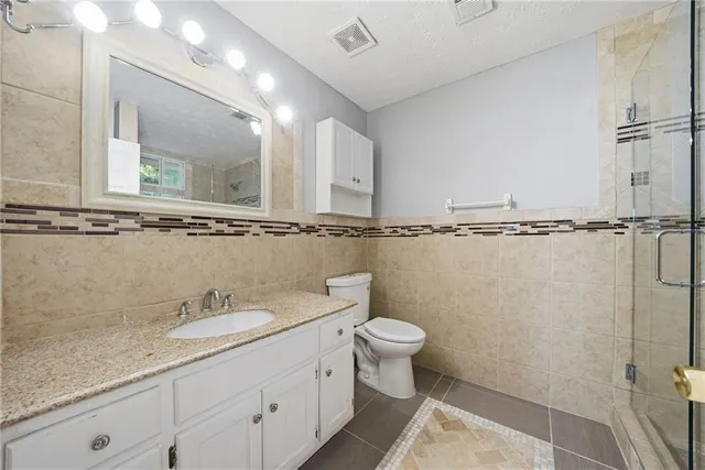 a bathroom with a granite countertop sink a toilet and a mirror