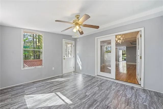 a view of an empty room with window and wooden floor