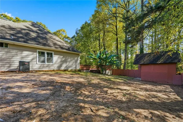 a backyard of a house with plants and large trees