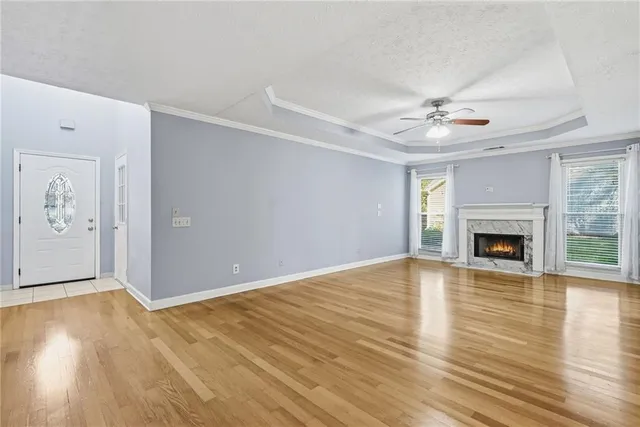 wooden floor fireplace and windows in an empty room