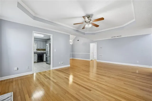 a view of an empty room with window and wooden floor