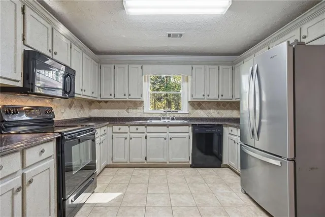 a kitchen with granite countertop cabinets stainless steel appliances and a counter space