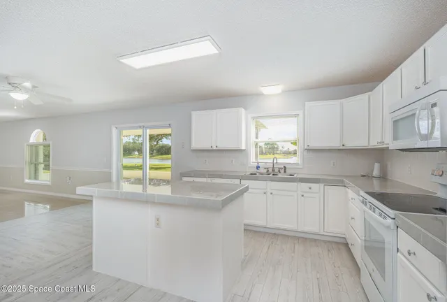 a kitchen with white cabinets and white appliances