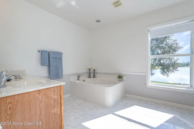 a bathroom with a tub sink and mirror
