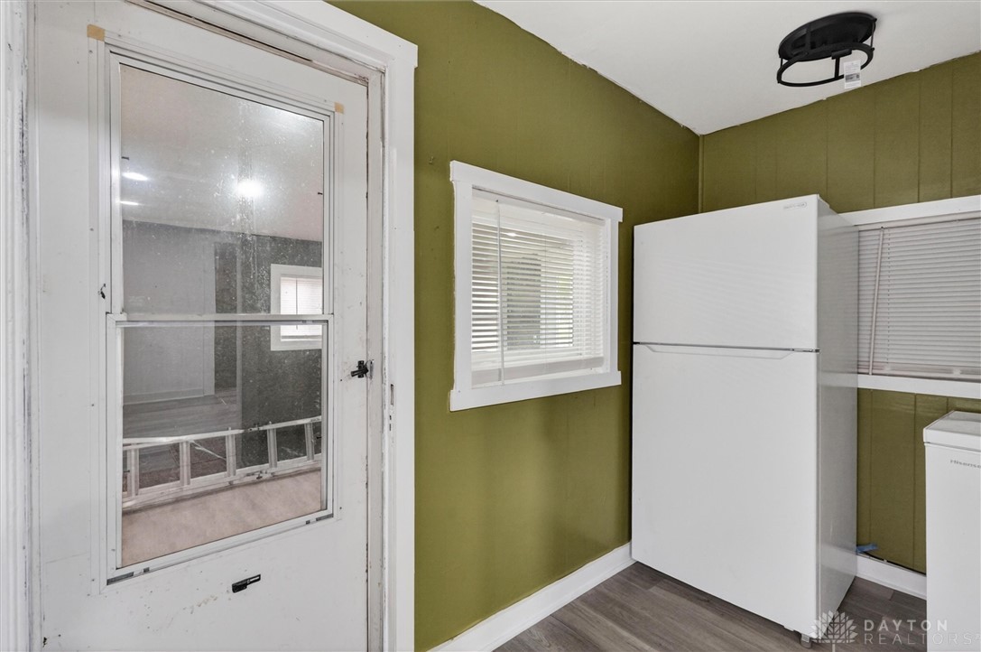 1726 Morgan Street Springfield, OH 45503 - Photo 19 of 30 This functional kitchen space features a window with blinds, a refrigerator, and a door for backyard access.