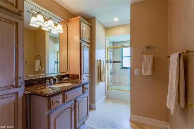 a bathroom with a granite countertop sink a mirror and a shower