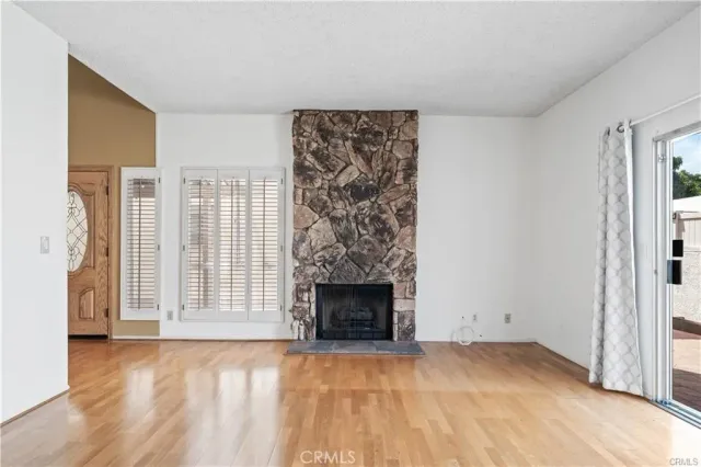 a view of empty room with fireplace and wooden floor