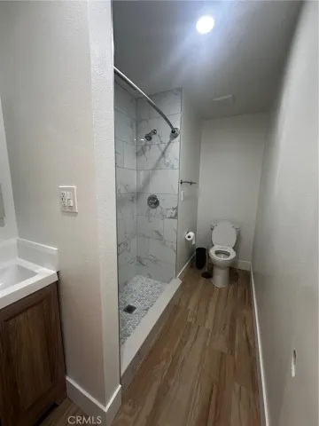 a bathroom with a sink a toilet a mirror and shower