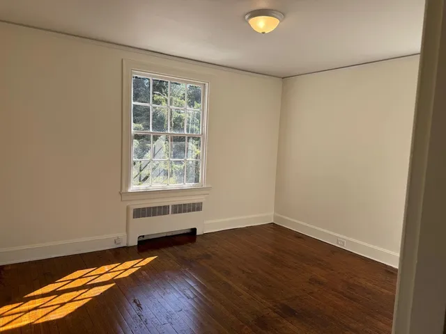 a view of room with window and wooden floor