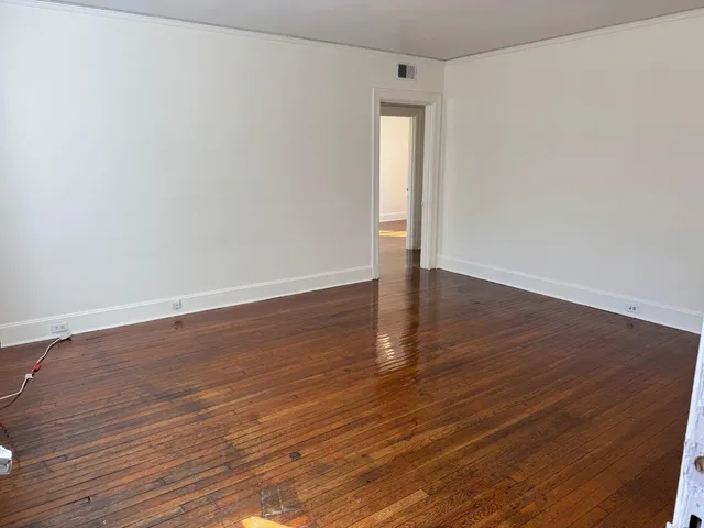 a view of an empty room with wooden floor