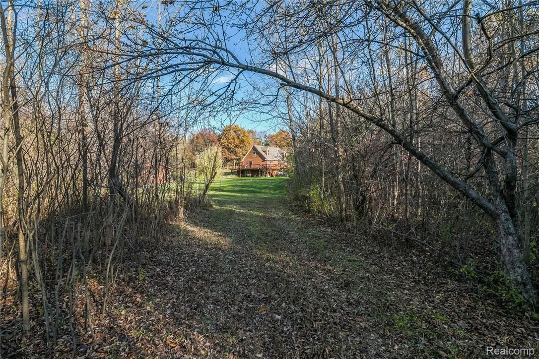277 North Baldwin Road Oxford, MI 48371 - Photo 41 of 45 VIEW FROM THE WIDE TRAIL AT THE WEST SIDE OF THE PROPERTY - YOU CAN DRIVE ALL AROUND THE BACK OF THE WOODS & BACK OUT THE OTHER SIDE
