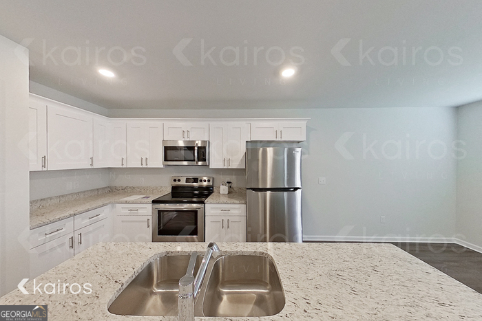 205 Redwood Court Springfield, GA 31329 - Photo 5 of 13 a kitchen with a sink a refrigerator and a stove top oven