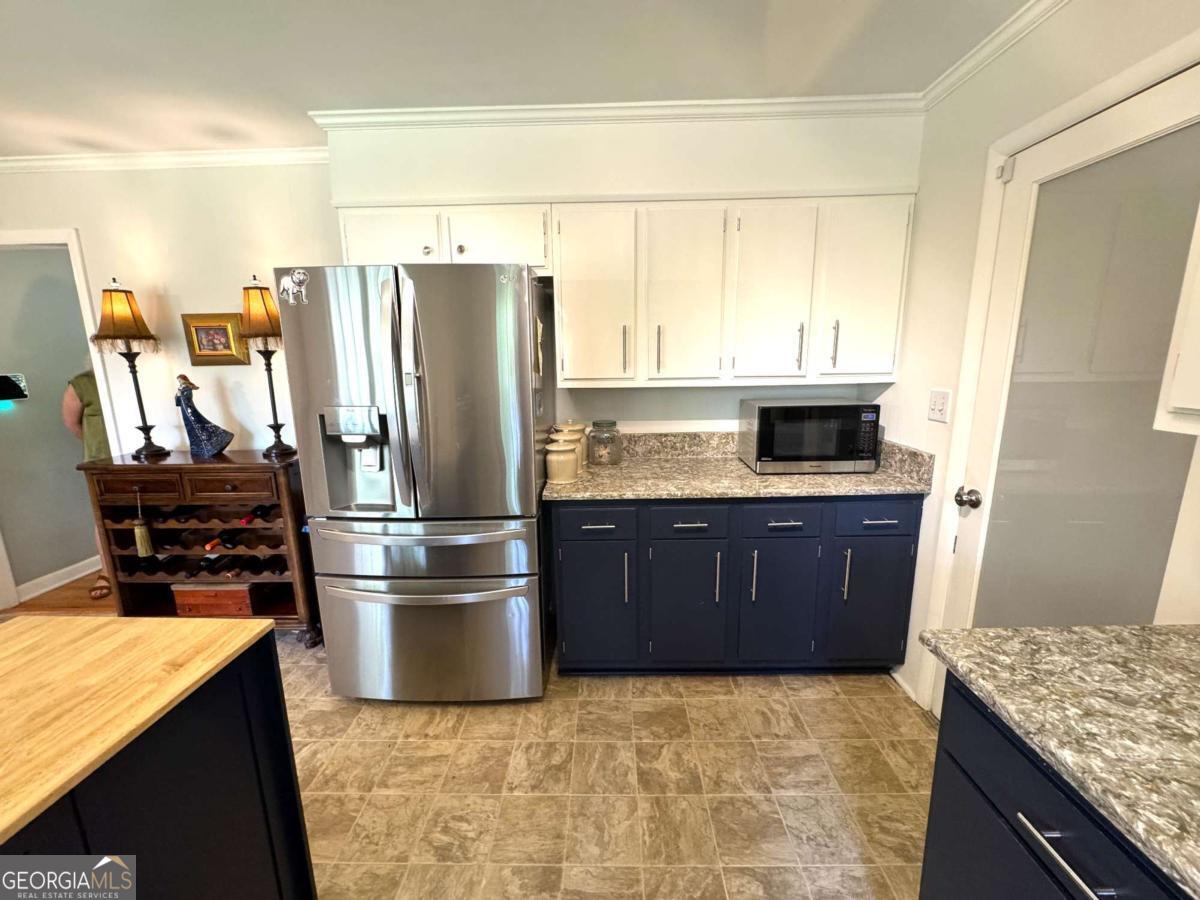149 Caroline Avenue Athens, GA 30606 - Photo 11 of 42 a kitchen with stainless steel appliances granite countertop a refrigerator a stove and a sink with wooden cabinets