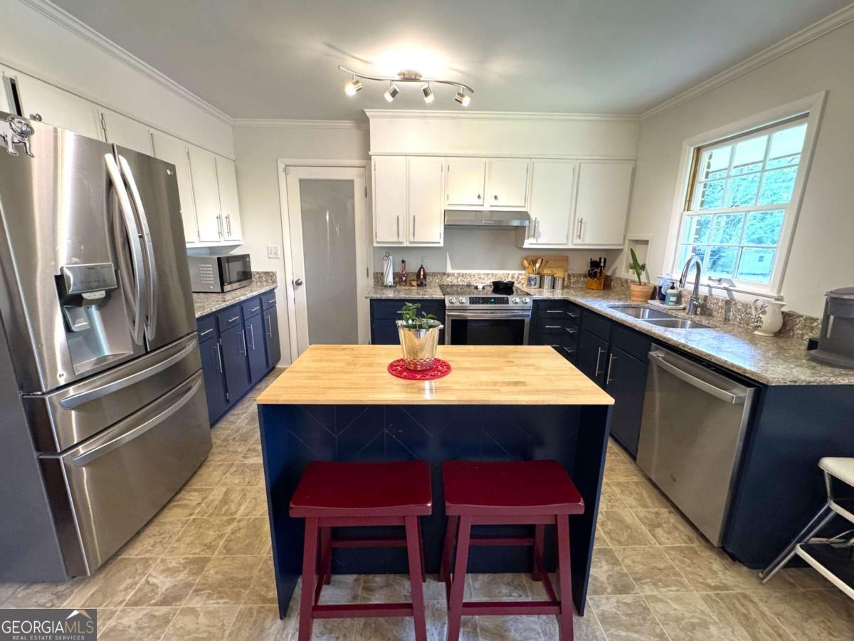 149 Caroline Avenue Athens, GA 30606 - Photo 8 of 42 a kitchen with stainless steel appliances a dining table chairs refrigerator and sink