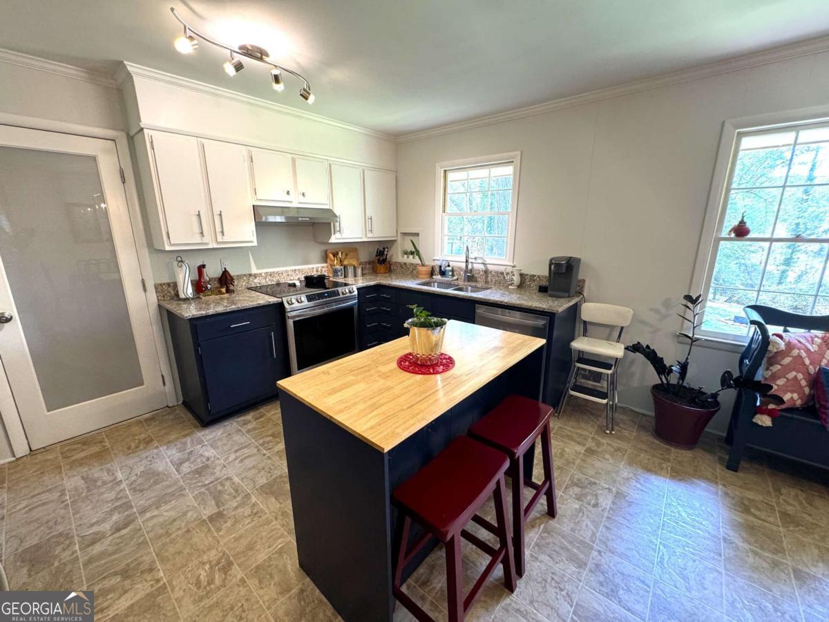 149 Caroline Avenue Athens, GA 30606 - Photo 9 of 42 a kitchen with a stove a refrigerator and a dining table