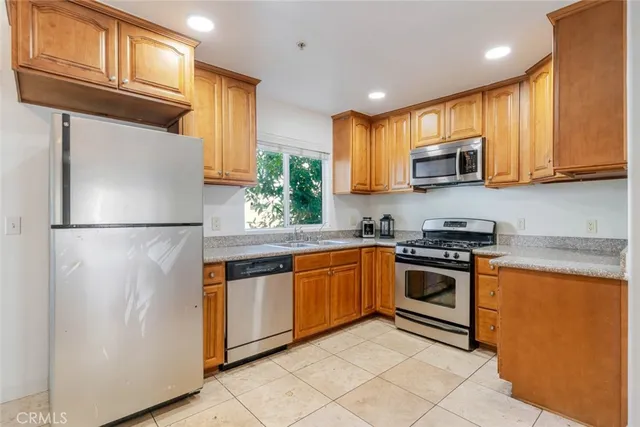 a kitchen with stainless steel appliances granite countertop a stove a sink and a refrigerator