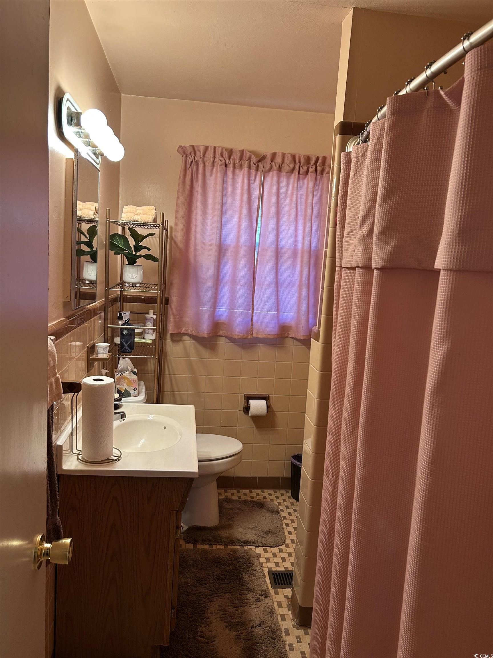 1411 East Harrison Street Dillon, SC 29536 - Photo 28 of 40 Full bathroom with vanity, tile walls, a shower with shower curtain, and tile patterned flooring