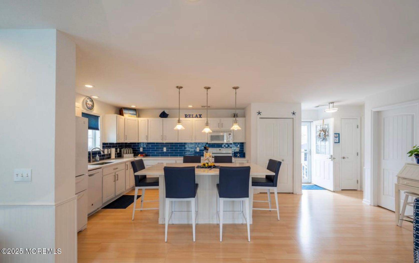 136 Joseph Street Lavallette, NJ 08735 - Photo 7 of 24 a kitchen with stainless steel appliances kitchen island granite countertop a dining table chairs and white cabinets